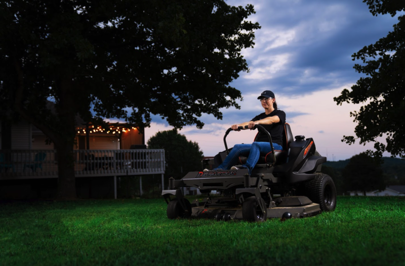 Person mowing lawn at dusk