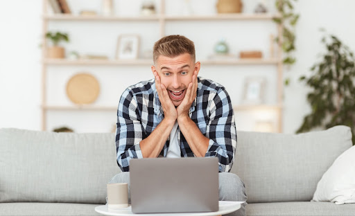 Man looking at his computer excited and surprised