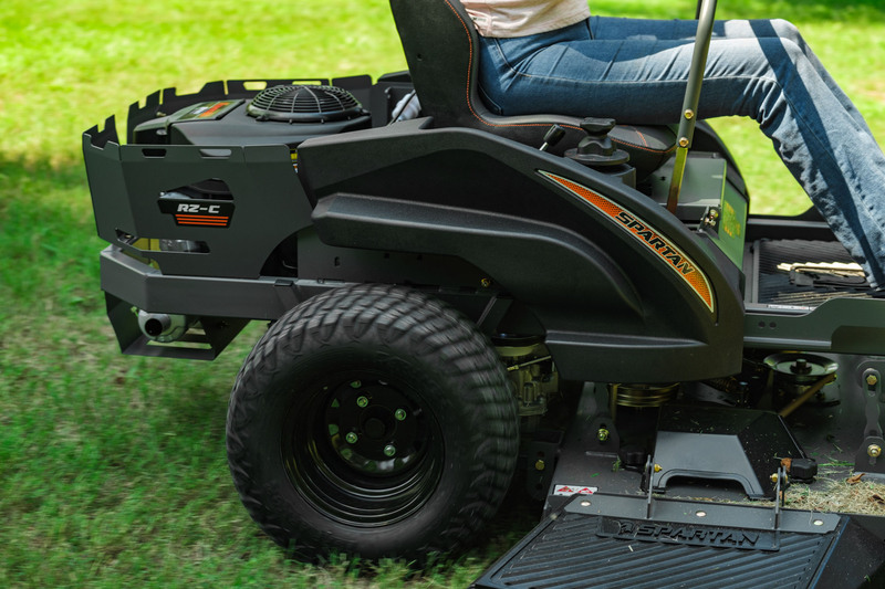 Side view of woman riding spartan mower in yard