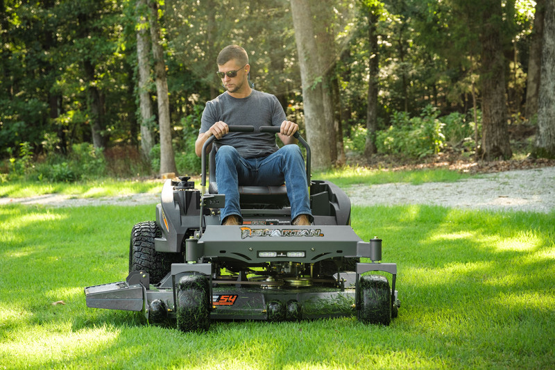 Front view of man driving RZ mower with road in background